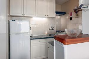 a kitchen with white cabinets and a white refrigerator at Europe 0402 in Sint-Idesbald +13 photos