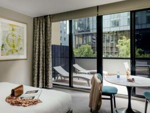 a hotel room with a bed and a large window at The Olsen Melbourne Art Series in Melbourne