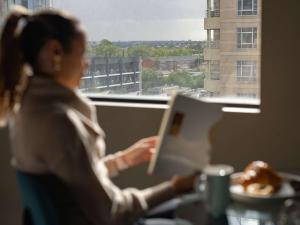 a woman sitting at a table reading a book at The Olsen Melbourne Art Series in Melbourne