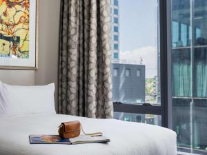 a hotel room with a bed and a window at The Olsen Melbourne Art Series in Melbourne