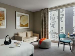 a hotel room with a bed and a couch and a window at The Olsen Melbourne Art Series in Melbourne