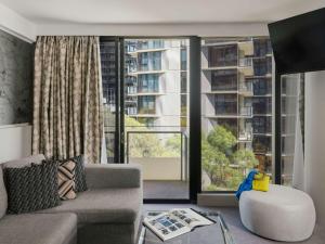 a living room with a couch and a large window at The Olsen Melbourne Art Series in Melbourne