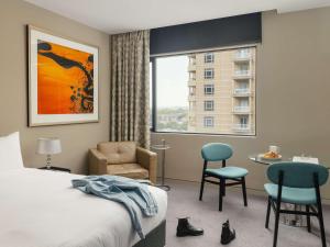 a hotel room with a bed and a chair and a window at The Olsen Melbourne Art Series in Melbourne