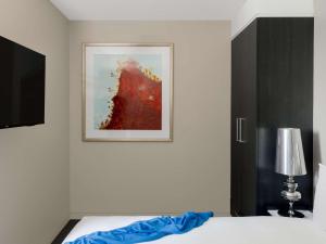 a bedroom with a bed and a picture on the wall at The Olsen Melbourne Art Series in Melbourne