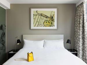 a bed with a yellow purse sitting on top of it at The Olsen Melbourne Art Series in Melbourne