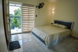 ein Schlafzimmer mit einem Bett und einer Glasschiebetür in der Unterkunft Vcode HillView in Thodupuzha