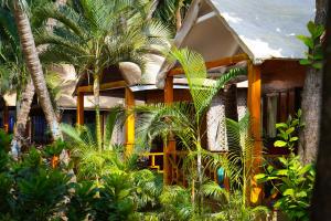 a house with palm trees in front of it at Sameer beachfront Cottages in Canacona