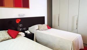 レッジョ・エミリアにあるRelais Delle Veleのベッドルーム1室(ベッド2台、テーブルの上に花1本付)