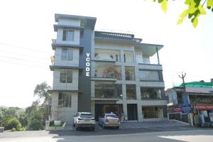 ein Gebäude mit zwei davor geparkten Autos in der Unterkunft Vcode HillView in Thodupuzha