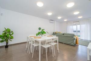 a white dining room with a white table and chairs at Jouvacations Ripolles Figueres-Vilafant in Vilafant