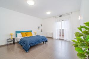 a bedroom with a bed with blue and yellow pillows at Jouvacations Ripolles Figueres-Vilafant in Vilafant