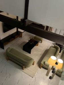 a living room with a green couch and a table at Fachwerk Borovoe in Shchūchīnsk