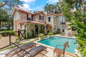 a home with a swimming pool in front of a house at Gull Cottage and Guest House - 757 Ocean Blvd in Saint Simons
