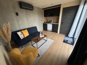 a living room with a blue couch and a table at Logement zen indépendant avec jardin et parking in Cornillé