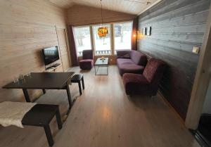a living room with a couch and a table at Skysstasjonen Cottages in Røldal