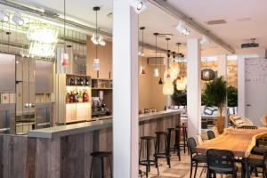 a restaurant with a long bar with chairs at CENTRAL Hôtel Bordeaux Centre in Bordeaux