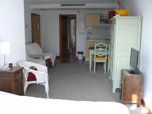 ein Zimmer mit einer Küche und einem Wohnzimmer mit einem TV in der Unterkunft Studio Lumineux, Coeur De Ville in Dijon