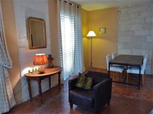 a living room with a chair and a table at Appartement Petite Saunerie in Avignon