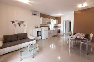 a living room with a couch and a table and a kitchen at The Golden Island apartments in Krk