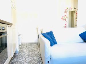 Una sala de estar con un sofá blanco y almohadas azules. en Prada District Milan Apartment, en Milán 21 fotos más