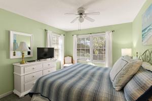 a bedroom with a bed and a ceiling fan at OceanWood, Unit 112 in East End