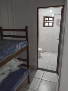 a bathroom with a bed and a toilet and a shower at Quarto compartilhado in Bertioga