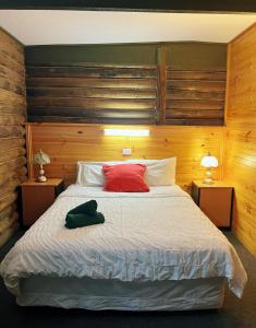 a bedroom with a bed with a teddy bear on it at Lakes Entrance Log Cabins in Lakes Entrance