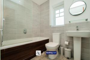 a bathroom with a toilet and a sink and a mirror at 2 Bedroom House By AR Properties Short Lets & Serviced Accommodation Colchester with Garden in Colchester +21 photos