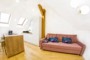 a living room with a couch and a kitchen at Apartament Parkowa 9 PENTHOUSE in Lesko