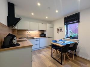 a kitchen with white cabinets and a table with chairs at Ferienwohnung Pöhlwasserblick in Pöhla +13 photos