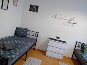 a room with a bed and a dresser and a lamp at Stellas Monteurwohnungen in Werdau