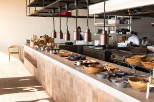 a kitchen with a long counter with food on it at KOIA All - Suite Well Being Resort - Adults Only in Ágios Fokás +87 photos