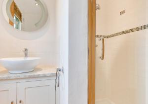 a white bathroom with a sink and a mirror at Pheasant Lodge in Reepham +26 photos