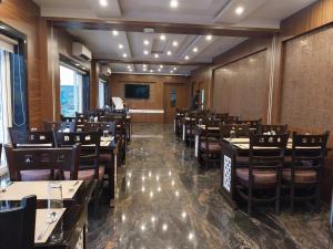 a restaurant with tables and chairs in a room at Sagar Kuthi in Mandarmoni