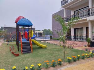 a playground in front of a building with flowers at Sagar Kuthi in Mandarmoni
