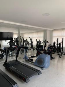 a gym with treadmills and elliptical machines at Apartamento completo no Guarujá in Guarujá