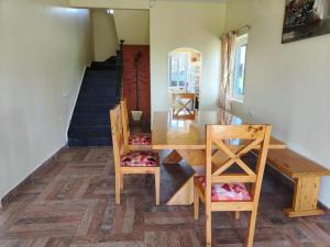 a dining room with a wooden table and chairs at Longwood Resorts in Kotagiri