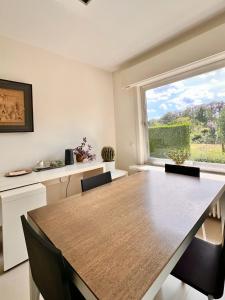 een eetkamer met een tafel en een groot raam bij B&B near Ghent in Merelbeke
