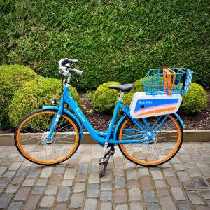 een blauwe fiets geparkeerd op een stoep met een mand bij B&B near Ghent in Merelbeke