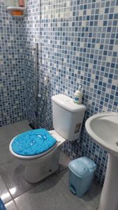 a blue tiled bathroom with a toilet and a sink at casa da mata in Ubatuba