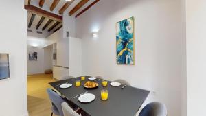 Un comedor con una mesa y sillas negras. en MyFlats Luxury City Center, en Alicante