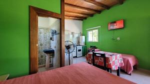 a green room with a bed and a kitchen at Las Calandrias in Valle Hermoso +24 photos