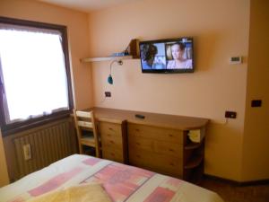 um quarto com uma cama e uma televisão na parede em Casa Paola em Valfurva