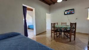 a bedroom with a table and chairs and a bed at Las Calandrias in Valle Hermoso