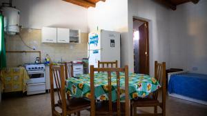 a kitchen with a table and chairs and a refrigerator at Las Calandrias in Valle Hermoso