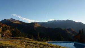 a view of a mountain range with a swimming pool at Superbe Studio Ambiance Chalet in Ustou