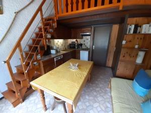 a kitchen with a wooden table and a staircase at Aiguille de Mey 12 in Pralognan-la-Vanoise