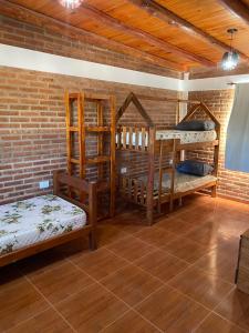 a room with two bunk beds and a brick wall at El Rincon de las Marias Casa en Planta Alta in San Lorenzo