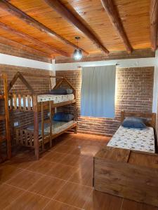 a room with two bunk beds and a brick wall at El Rincon de las Marias Casa en Planta Alta in San Lorenzo