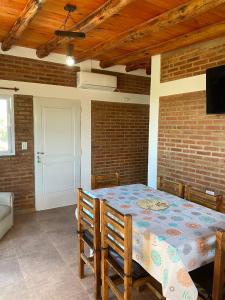 a dining room with a table and a brick wall at El Rincon de las Marias Casa en Planta Alta in San Lorenzo